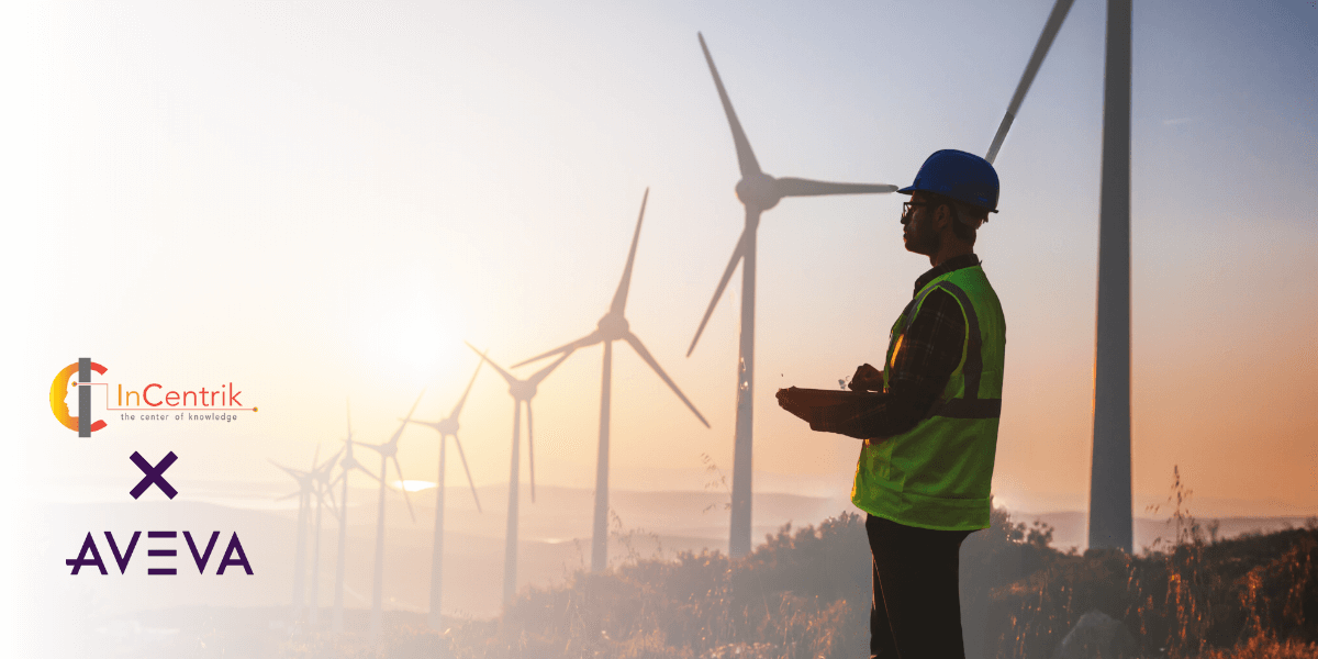 A renewable energy worker in a field that has windmills int he background. He is using a laptop to check data through AVEVA's PI Vision. He was trained using InCentrik's PI training programs.