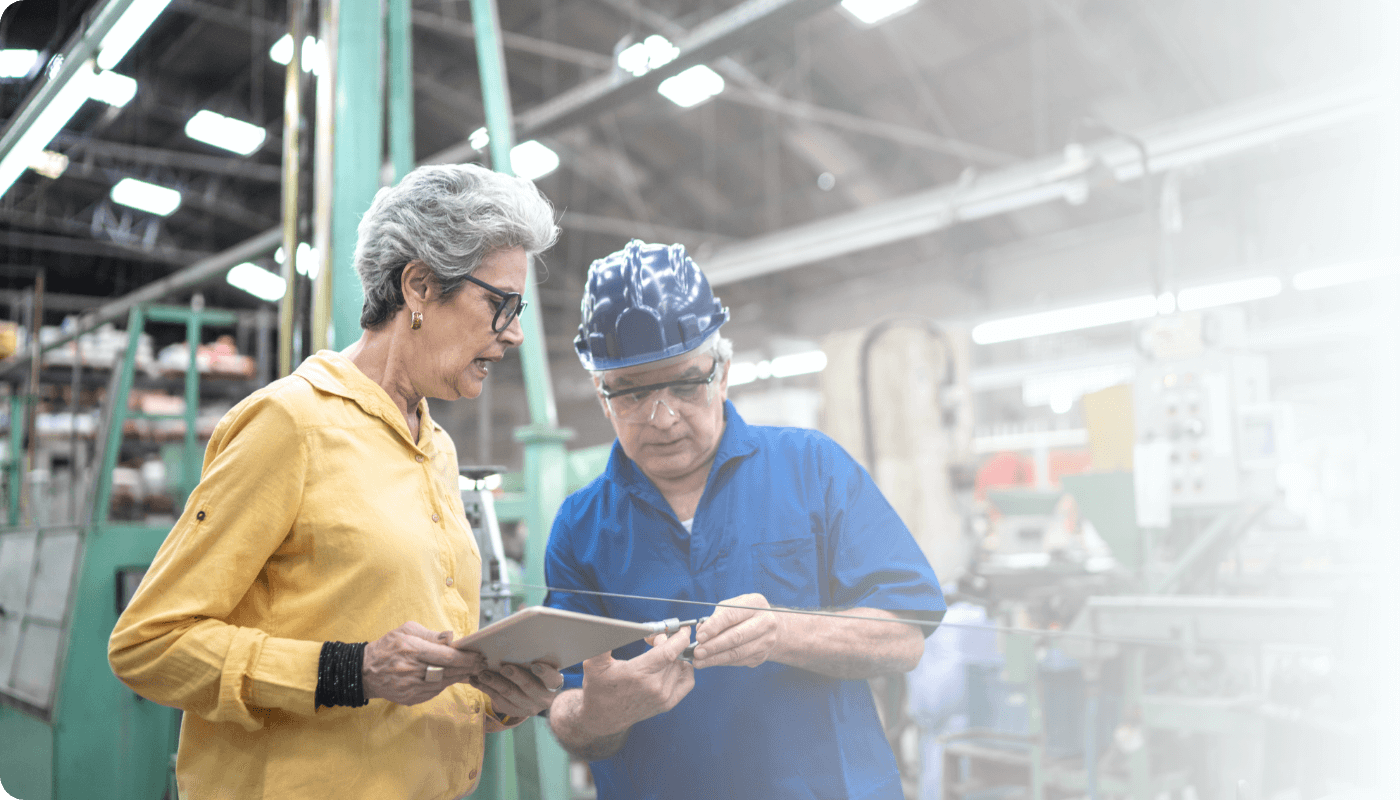 two female industrial workers looking at data on a clipboard while in a factory. (3) (1)
