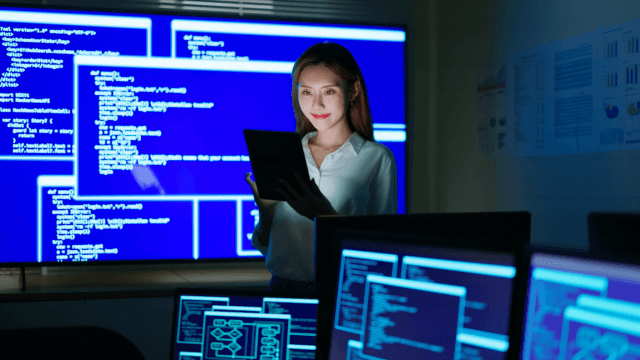 A woman in business attire using an ipad to check the security systems in a PI system. (1)