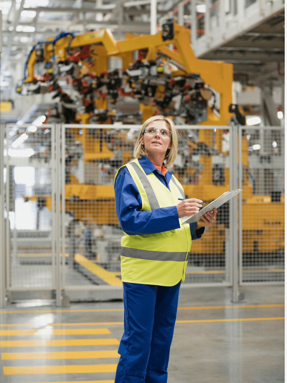 Manufacturing employee wearing hi-res vest with clipboard in manufacturing facility