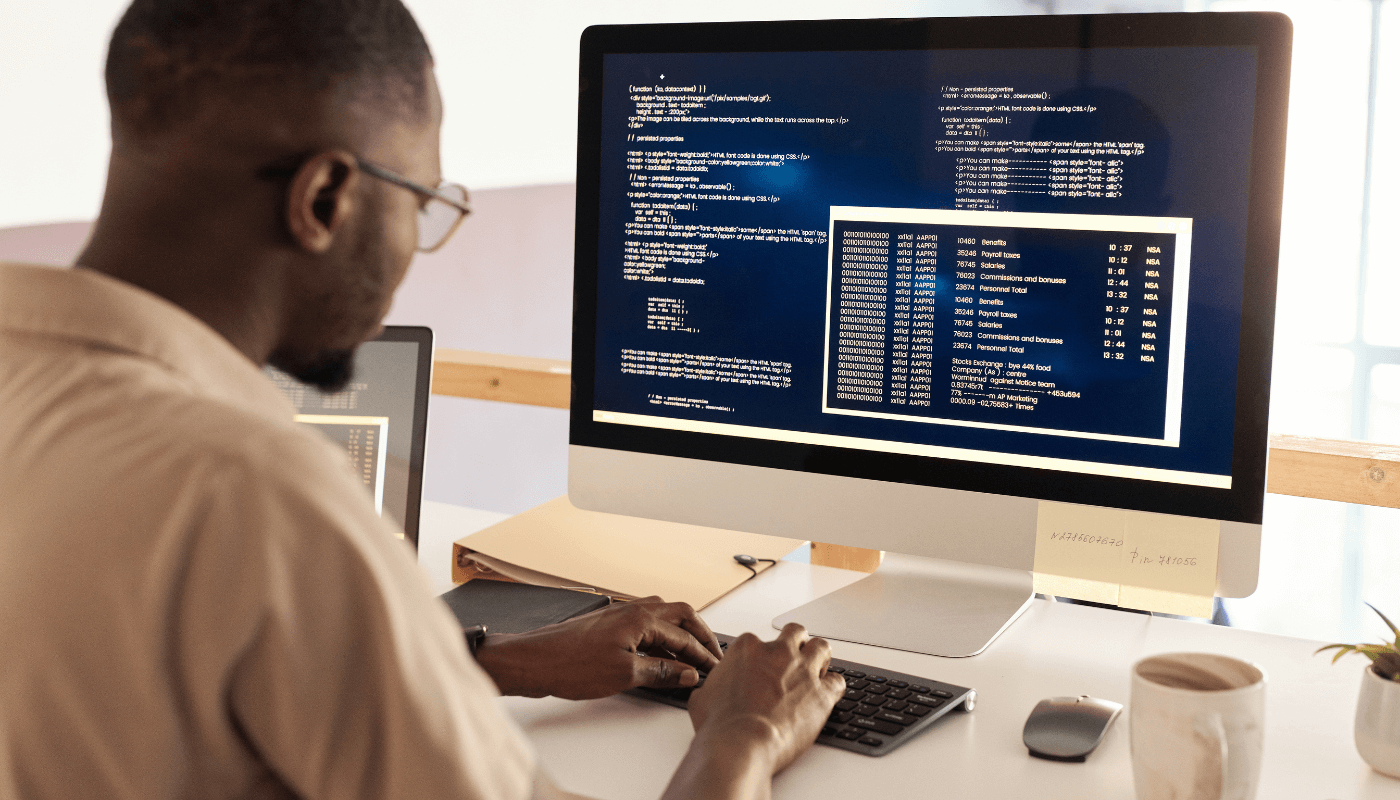 A man on a computer writing and debugging code.