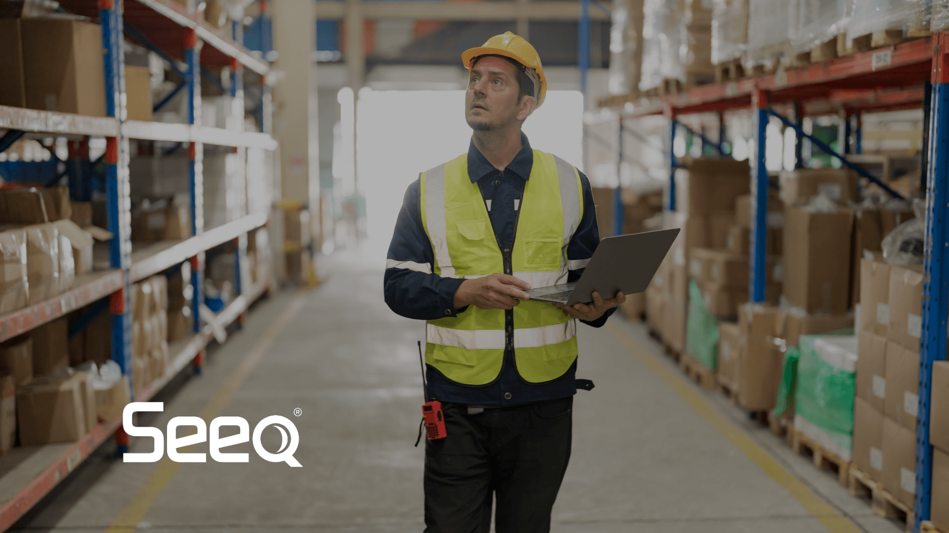 an industrial worker in a warehouse looking at data on a laptop (1)